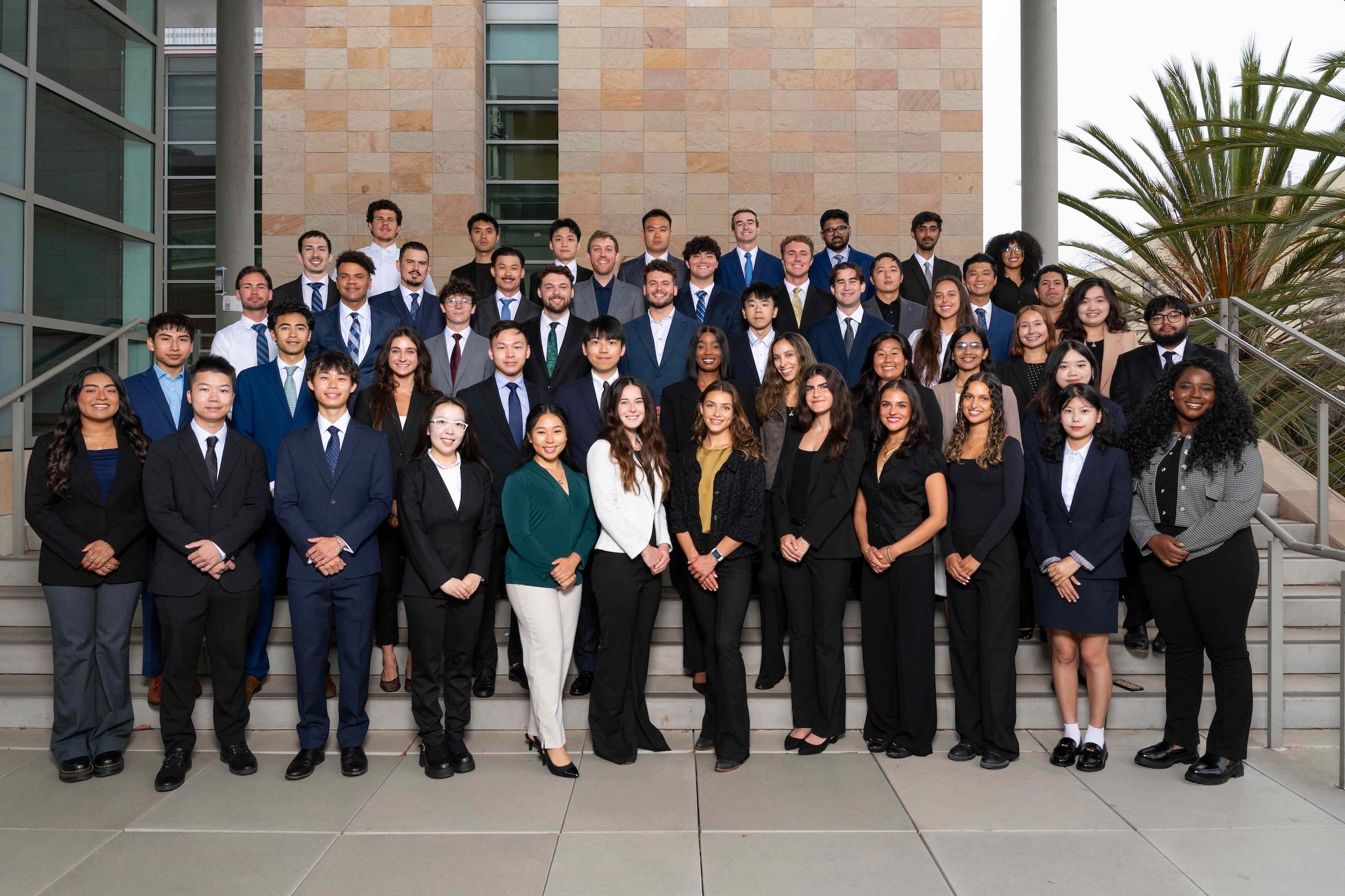 Technology Management students and staff posing for a group photo outside a campus building.